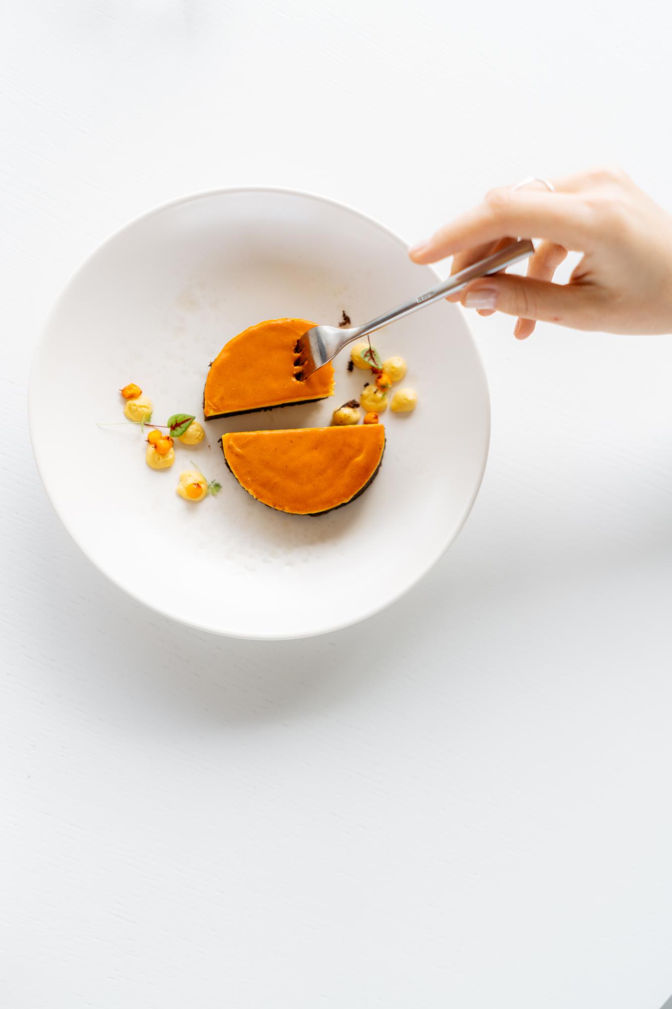Chef plating a simple seasonal dish on a ceramic plate